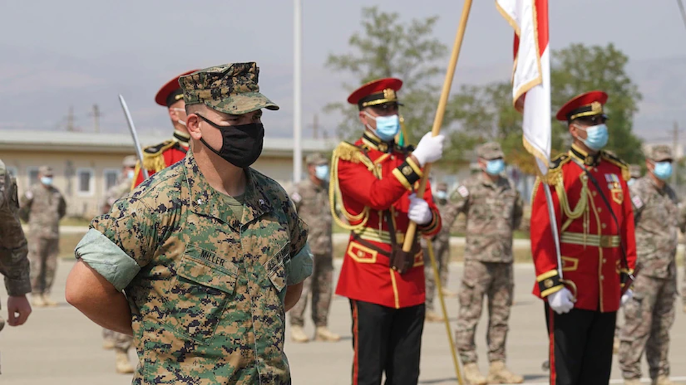 A U.S. military officer stands in formation alongside fellow service members.